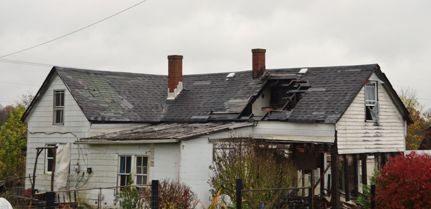 Before: worn asphalt roof with curling shingles and moss growth in the valley