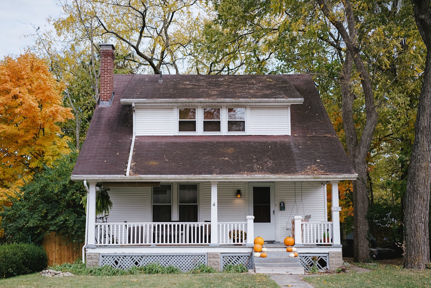Finished suburban home exterior with new roof, gutters and siding