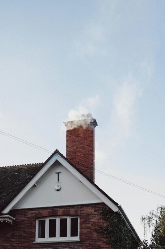 Chimney sweep cleaning a flue