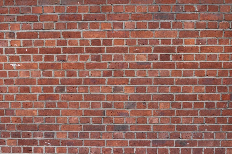 Mason repairing a brick wall